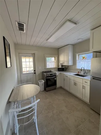 a kitchen with sink refrigerator and window