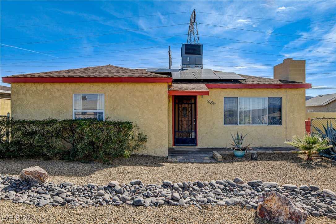 239 West Basic Road Henderson, NV 89015 - Photo 2 of 43 View of front facade featuring fence, stucco siding, a chimney, and solar panels