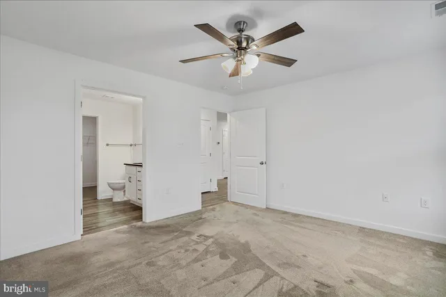 an empty room with closet and windows