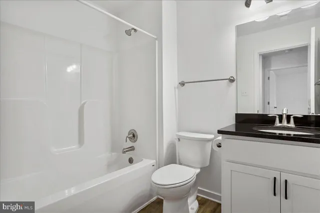 a bathroom with a sink toilet vanity and shower