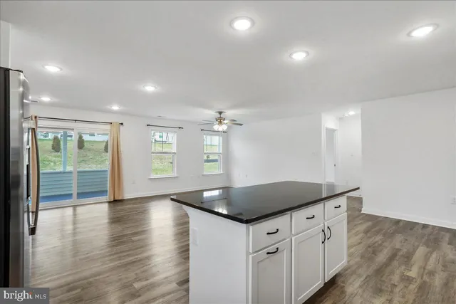 a kitchen with granite countertop a sink a stove and a wooden floors
