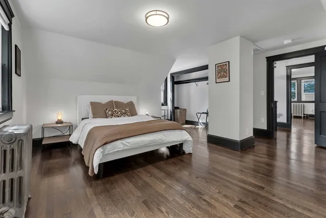 a bedroom with a bed and wooden floor