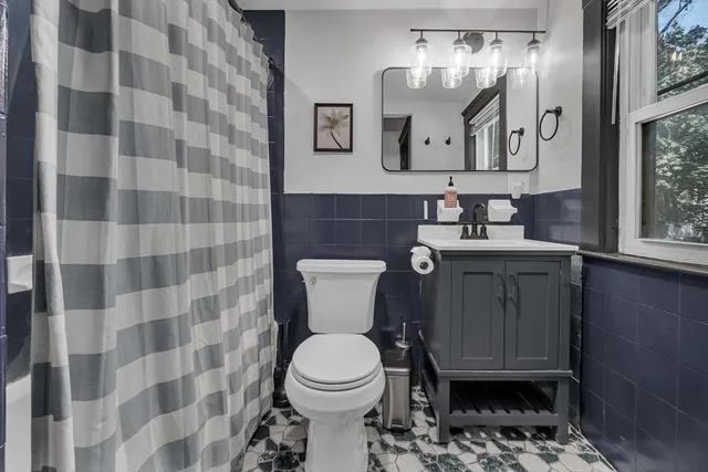 a bathroom with a toilet sink and mirror