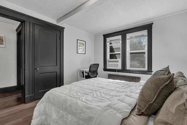 a bedroom with a bed and a large window