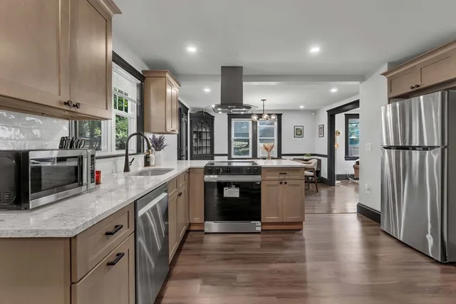 a kitchen with stainless steel appliances granite countertop a sink a stove and a refrigerator