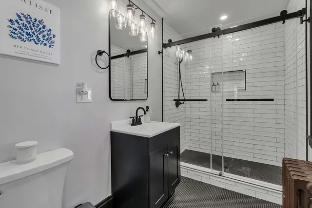 a bathroom with a sink a toilet and shower