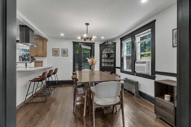 a view of a dining room with furniture a chandelier and wooden floor