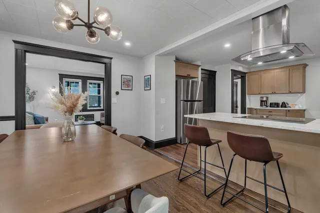 a kitchen with kitchen island a stove a table and chairs in it