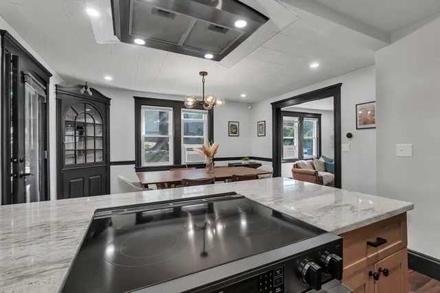 a kitchen with stainless steel appliances a stove a sink dishwasher and white countertops with wooden floor