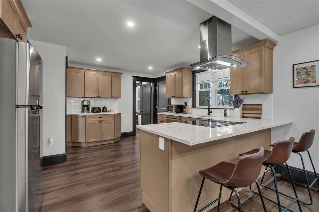 50 Sprague Street Dedham, MA 02026 - Photo 9 of 28 a kitchen with stainless steel appliances kitchen island granite countertop a sink refrigerator and cabinets