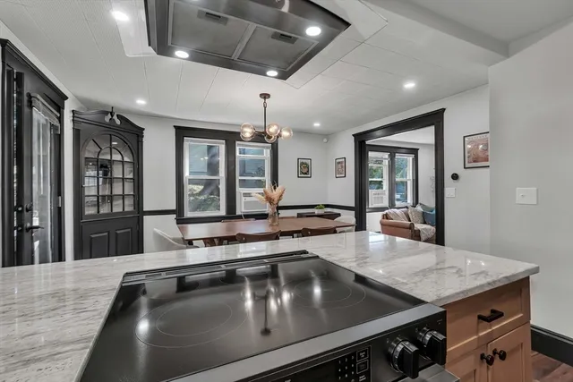 a kitchen with stainless steel appliances a stove a sink dishwasher and white countertops with wooden floor