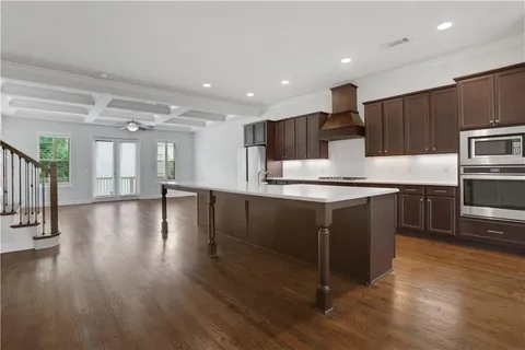 a kitchen with kitchen island granite countertop a stove top oven a sink and a microwave