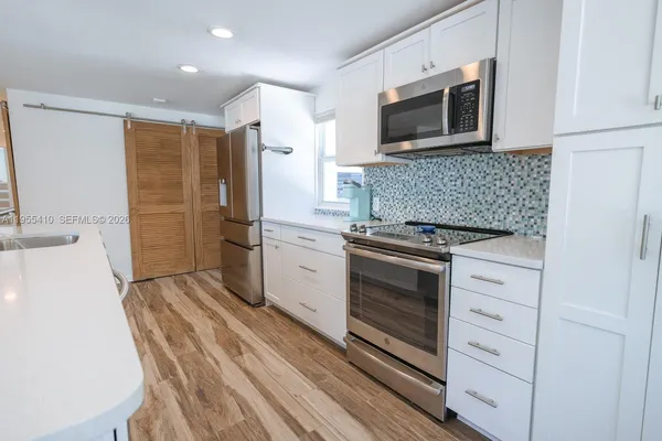 a kitchen with a sink stove and microwave