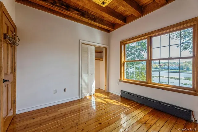 a view of a room with wooden floor and windows