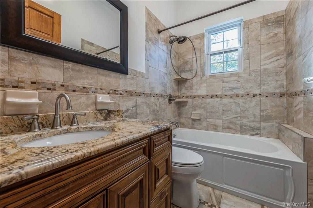 48 Lakewood Drive Congers, NY 10920 - Photo 6 of 19 a bathroom with a granite countertop sink a toilet and bathtub