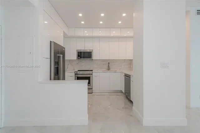 a kitchen with stainless steel appliances granite countertop a refrigerator and a sink