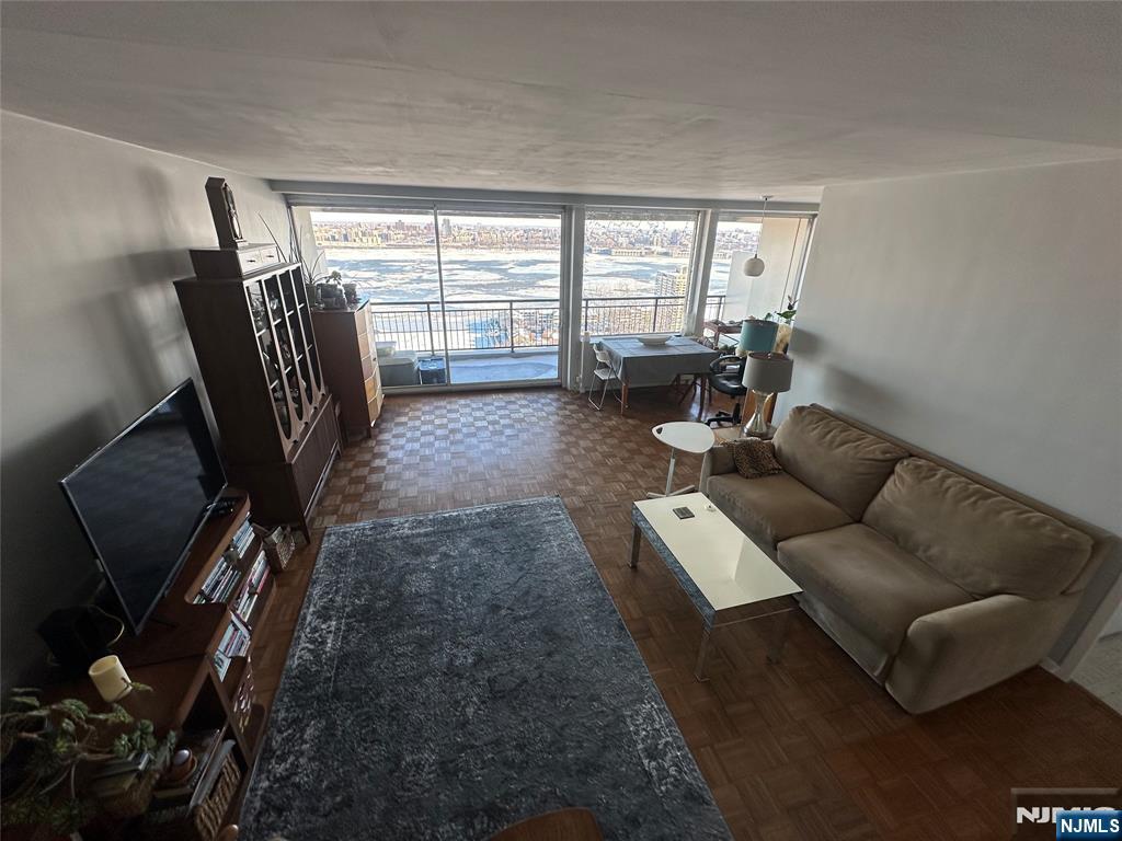 1 Horizon Road, Unit 1025 Fort Lee, NJ 07024 - Photo 17 of 27 a living room with furniture and a floor to ceiling window