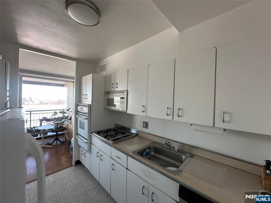 1 Horizon Road, Unit 1025 Fort Lee, NJ 07024 - Photo 4 of 27 a kitchen with sink cabinets and appliances