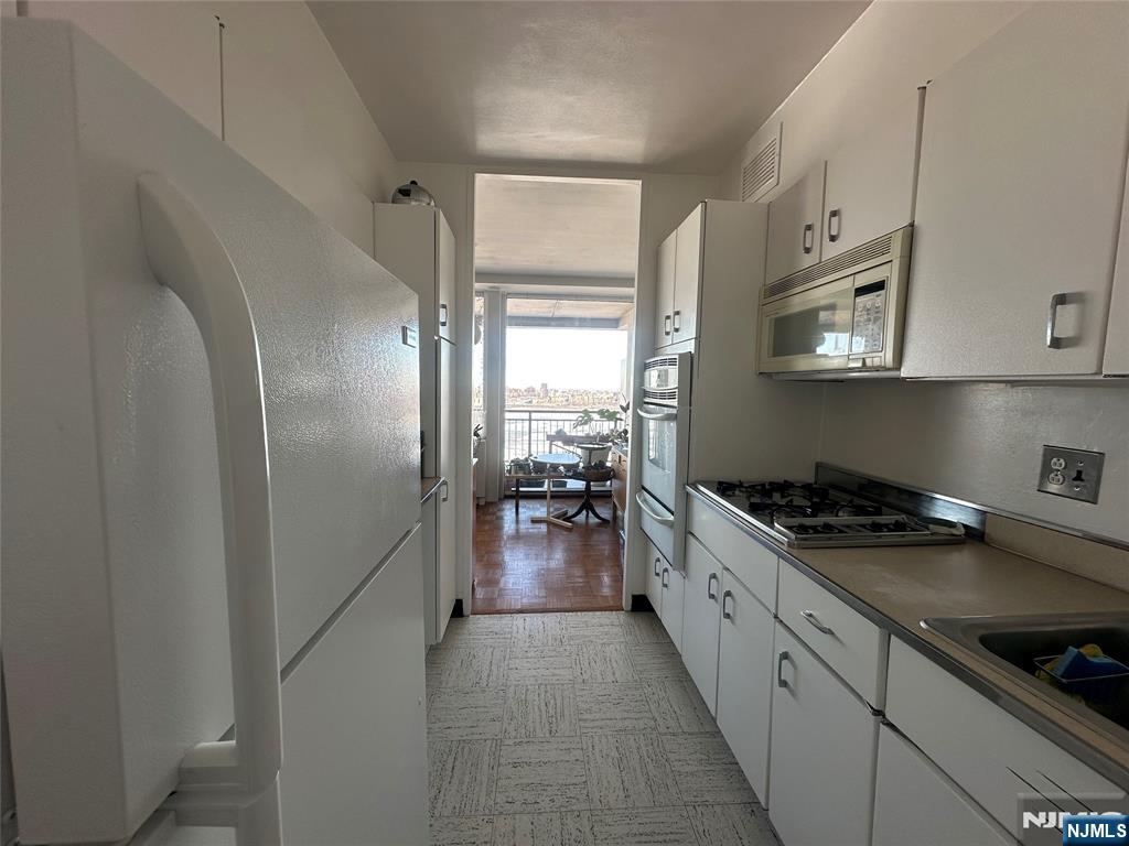 1 Horizon Road, Unit 1025 Fort Lee, NJ 07024 - Photo 6 of 27 a kitchen with granite countertop a stove and a refrigerator