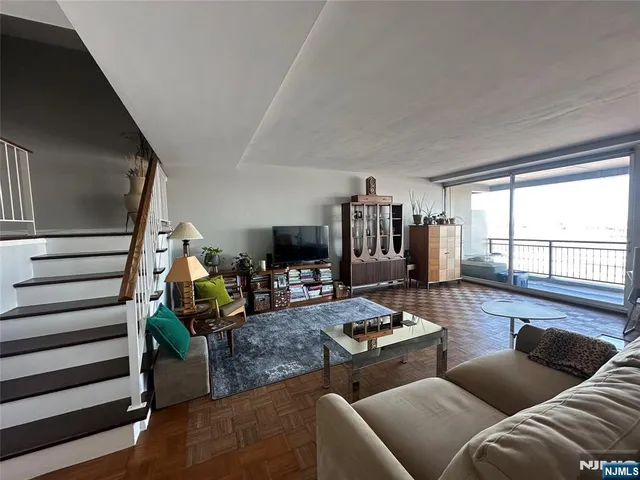 a living room with furniture and a floor to ceiling window