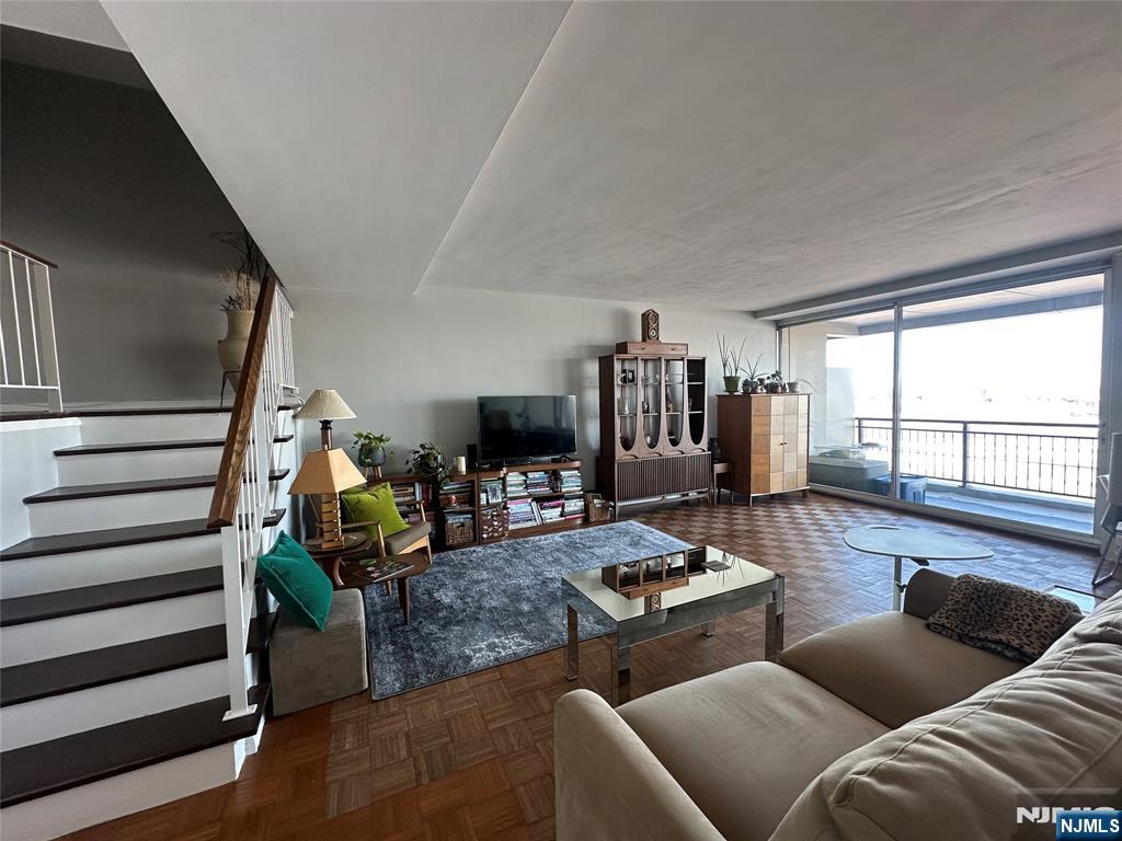 1 Horizon Road, Unit 1025 Fort Lee, NJ 07024 - Photo 7 of 27 a living room with furniture and a floor to ceiling window