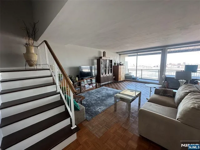 a living room with furniture and a book shelf