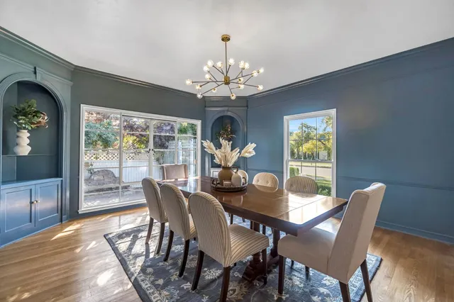 a view of a dining room with furniture a chandelier and wooden floor