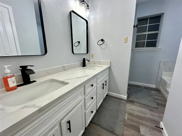 a spacious bathroom with double vanity and a mirror