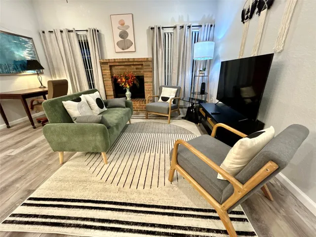 a living room with furniture a fireplace and a flat screen tv