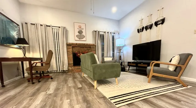 a living room with furniture a flat screen tv and a refrigerator