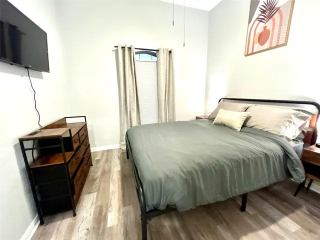 a bedroom with a bed and a flat screen tv