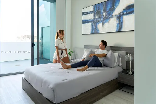 a bedroom with a bed and glass wall
