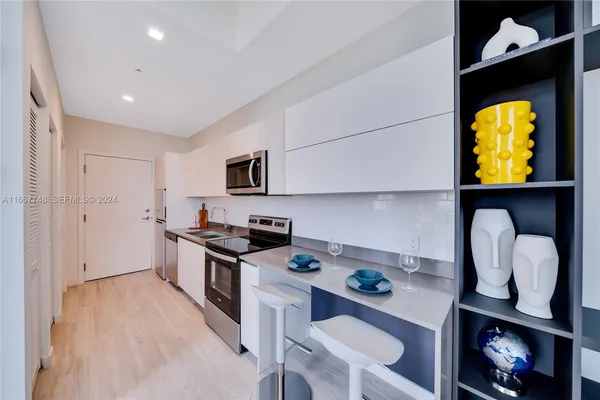 a kitchen with stainless steel appliances granite countertop a sink and a refrigerator