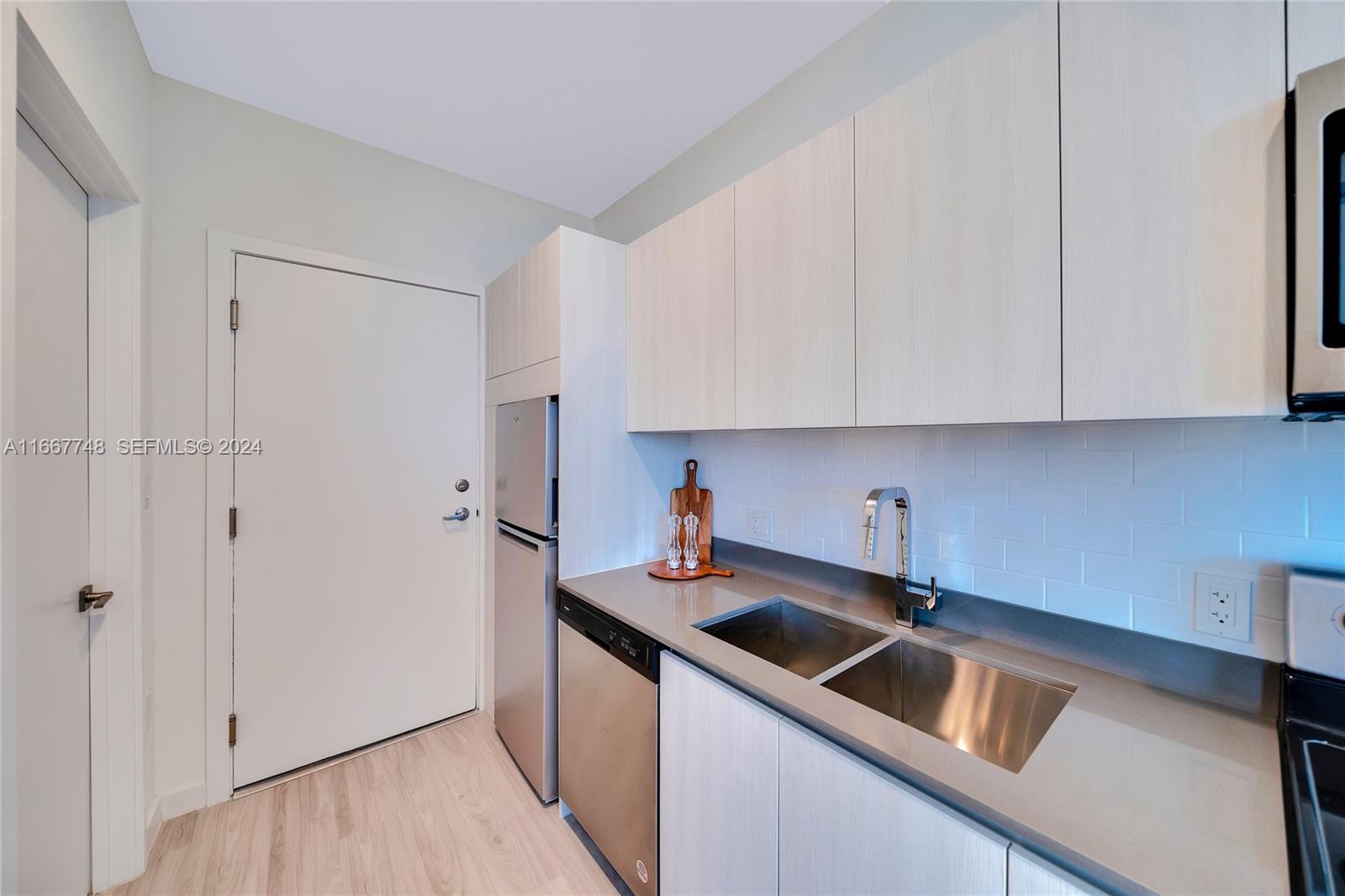 1809 Jackson Street, Unit 1002 Hollywood, FL 33020 - Photo 44 of 46 a kitchen with stainless steel appliances granite countertop a sink and a refrigerator