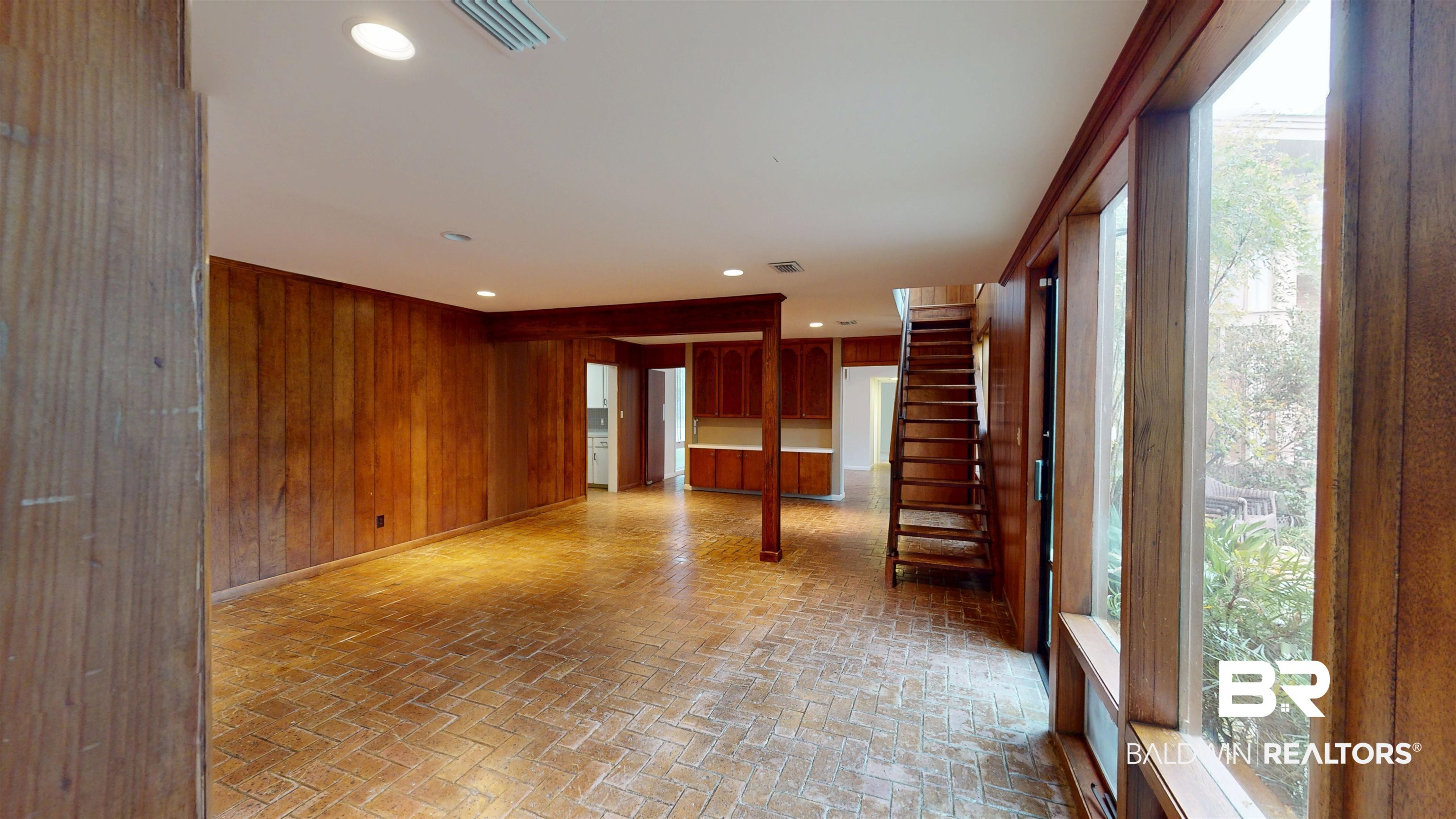15 Spring Bank Road Mobile, AL 36608 - Photo 22 of 58 Empty room with brick floors, wooden walls, recessed lighting, and stairway