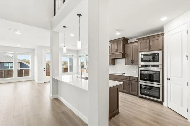 a kitchen with stainless steel appliances kitchen island wooden cabinets and granite counter tops