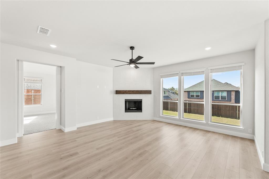 4213 Bel Air Drive Midlothian, TX 76065 - Photo 18 of 40 a view of a livingroom with wooden floor a ceiling fan and windows