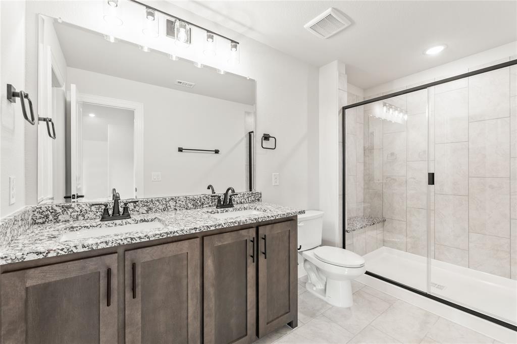 4213 Bel Air Drive Midlothian, TX 76065 - Photo 35 of 40 a bathroom with a granite countertop sink a toilet a mirror and shower