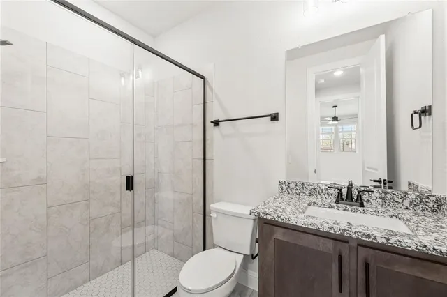 a bathroom with a granite countertop sink toilet and shower