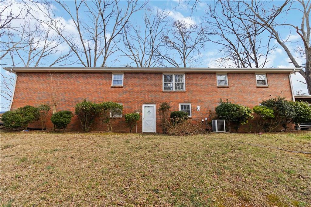 3829 Reynolds Road Douglasville, GA 30135 - Photo 18 of 24 a view of a brick house with large trees and a small yard