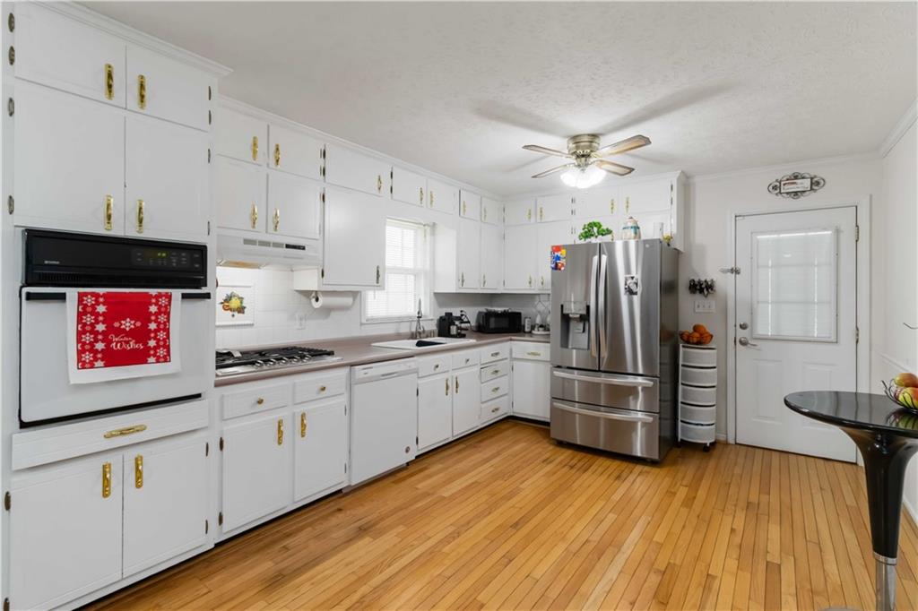 3829 Reynolds Road Douglasville, GA 30135 - Photo 8 of 24 a kitchen with kitchen island wooden floors appliances and cabinets