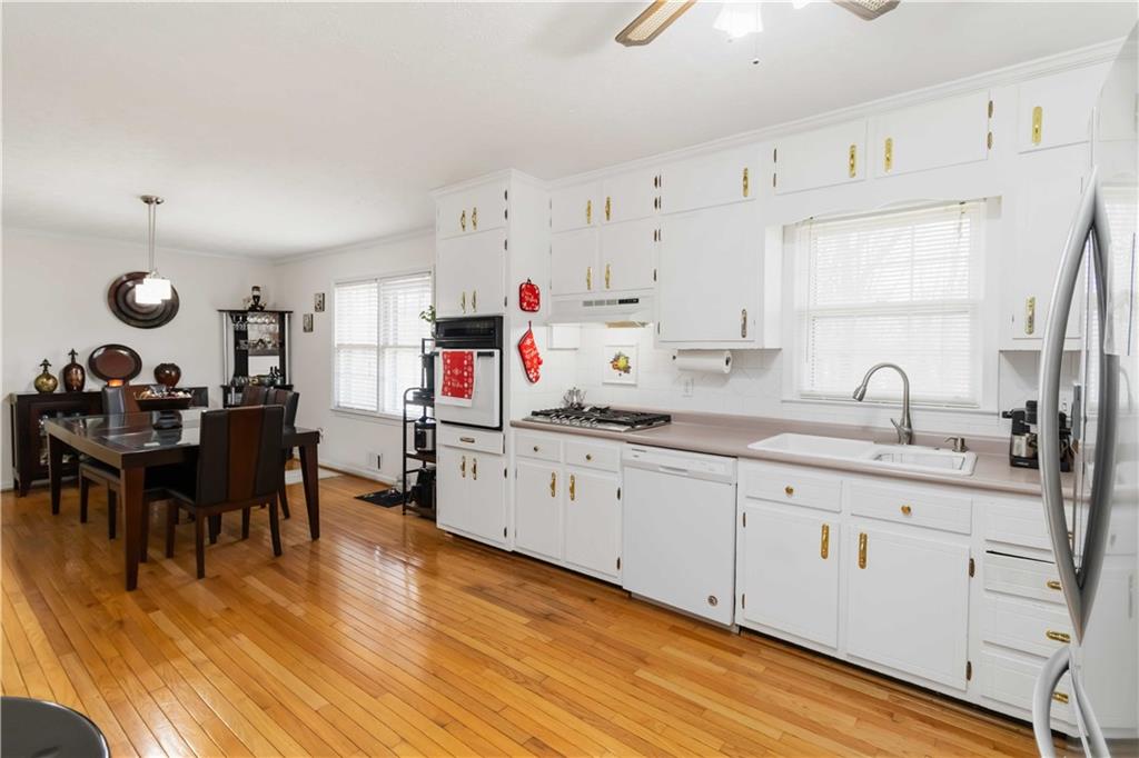 3829 Reynolds Road Douglasville, GA 30135 - Photo 10 of 24 a very nice looking kitchen with granite countertop a stove a sink a dining table and chairs with wooden floor