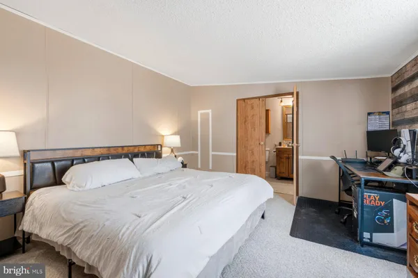 a bedroom with a bed and a computer on a table