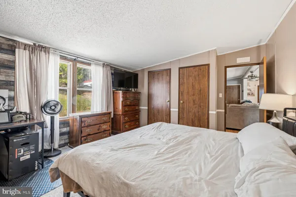 a bedroom with a large bed and a flat tv screen on dresser