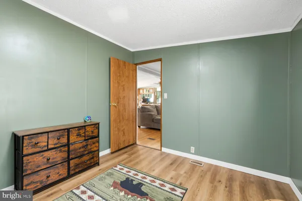 an empty room with wooden floor closet and windows
