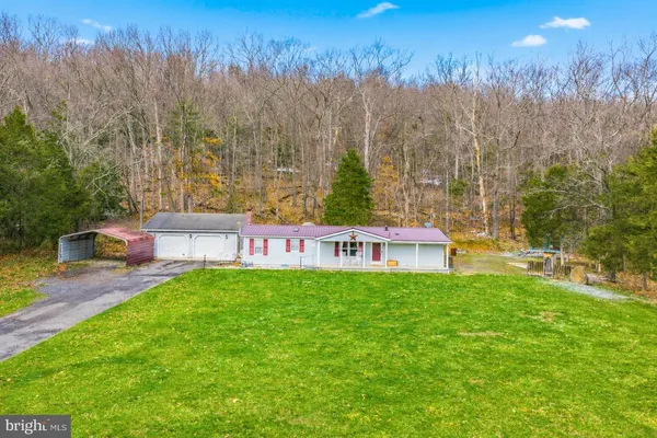 a view of a house with backyard and trees