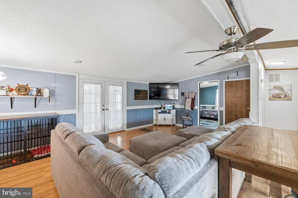 a living room with furniture a flat screen tv and kitchen view