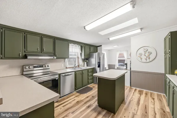 a kitchen with granite countertop cabinets stainless steel appliances and a counter space