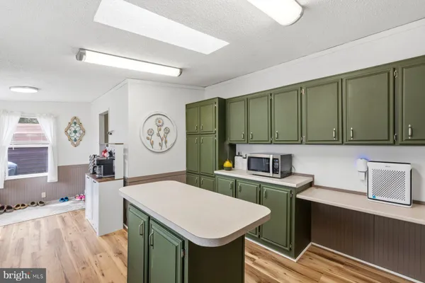 a view of a kitchen area with furniture and wooden floor