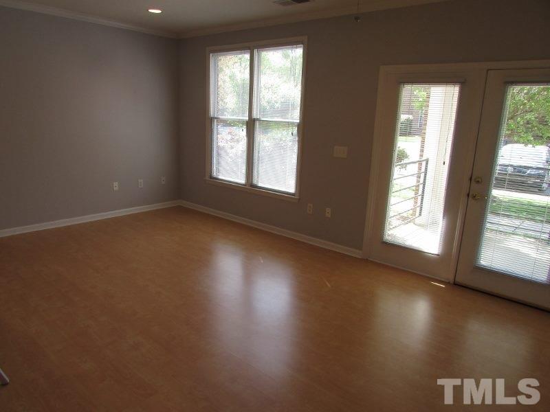 720 North Person Street, Unit 103 Raleigh, NC 27604 - Photo 3 of 13 an empty room with wooden floor and windows